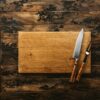 Wood cutting board with knife on rustic table