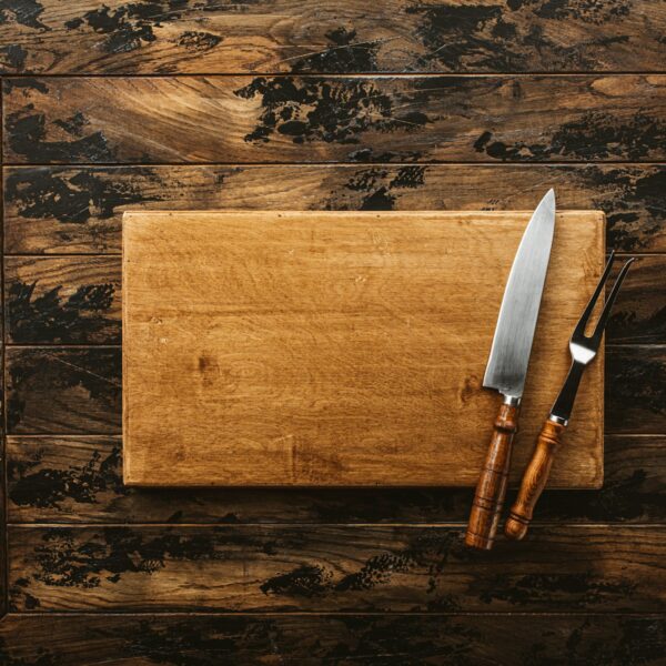 Wood cutting board with knife on rustic table
